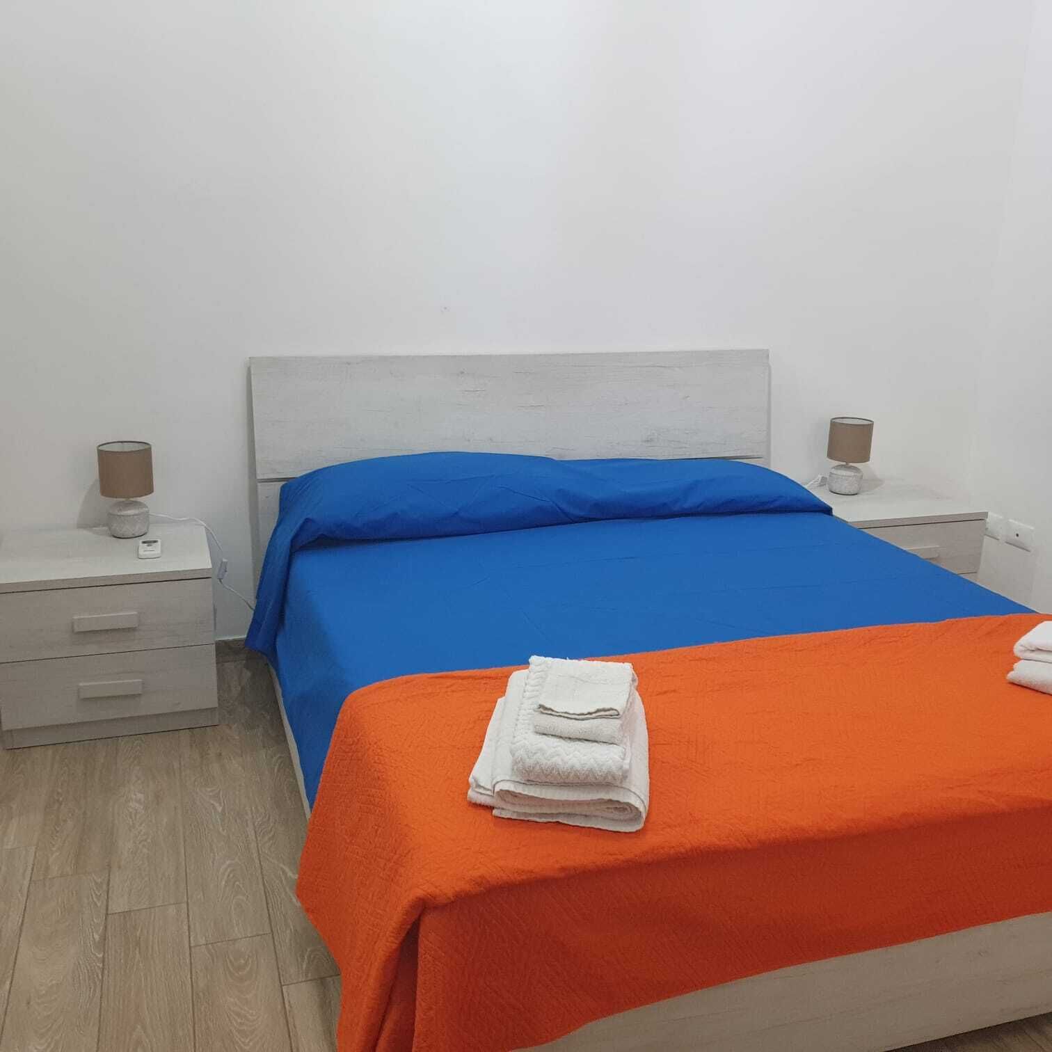 Un dormitorio con una cama, dos mesitas de noche y una mesilla.