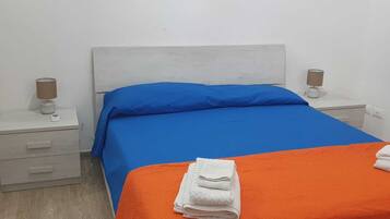 Un dormitorio con una cama, dos mesitas de noche y una mesilla.