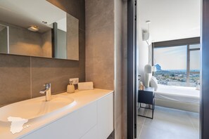 A modern bathroom with a large mirror, a sink, and a view of the city. - CostaBlancaDreams - Perla in Calpe (Calpe)