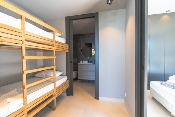 A bedroom with a bunk bed, a bathroom with a sink and mirror, and a wardrobe. - CostaBlancaDreams - Perla in Calpe (Calpe)