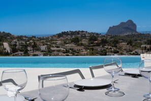 A dining table with empty plates and wine glasses, overlooking a coastal town and a clear blue sky. - CostaBlancaDreams - Perla in Calpe (Calpe)