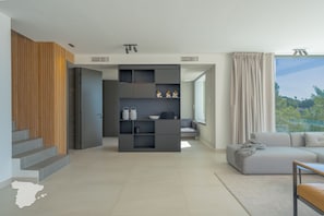 A modern living space with a built-in bookshelf, a sofa, and a view of the outdoors. - CostaBlancaDreams - Perla in Calpe (Calpe)