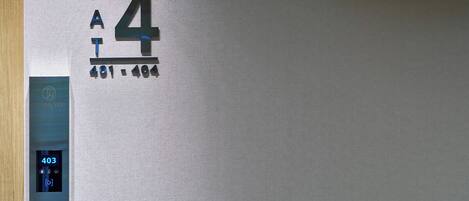 A wall with the number '4' and 'KAT' indicating room number 4. There is a digital display showing '403' and a 'THANK YOU' sign above it.