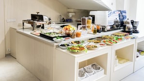 Ein reichhaltiges Buffet mit verschiedenen Speisen, einer Kaffeemaschine und Geschirr.