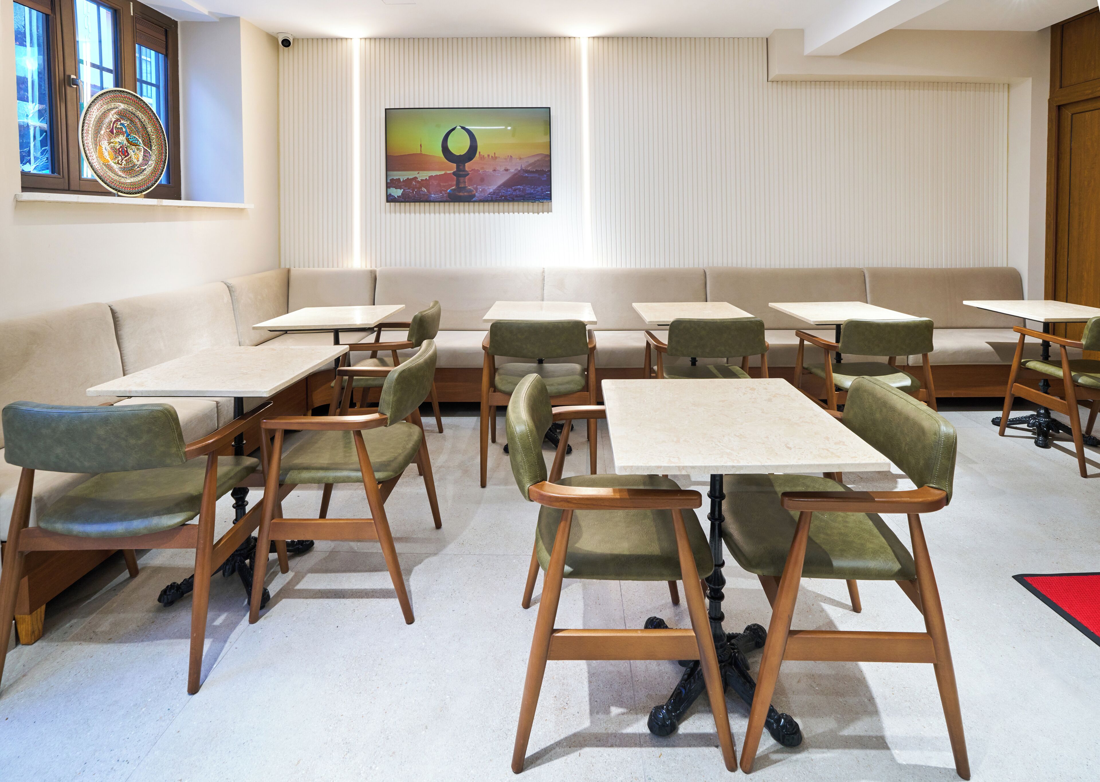 Une salle de réunion moderne dotée d’une grande fenêtre, d’un tableau accroché au mur, et d’un assortiment de tables et de chaises.
