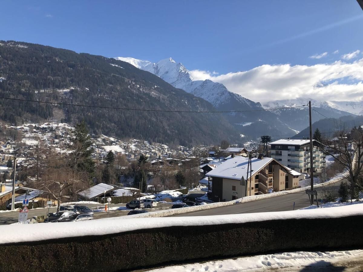 Une ville de montagne enneigée, avec des bâtiments et une route.