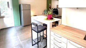 Une cuisine moderne équipée d’un réfrigérateur, d’un évier et d’un coin repas avec une chaise et une table.