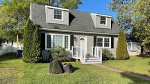 A two-story house with a front porch, a small deck, and a well-maintained lawn. - Beechwood by the Bay Dog Friendly (Lower Township)