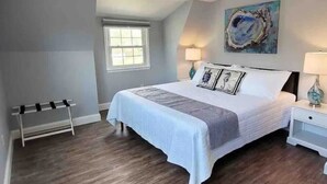 A bedroom with a bed, bedside tables, a window, and a painting on the wall. - Beechwood by the Bay Dog Friendly (Lower Township)