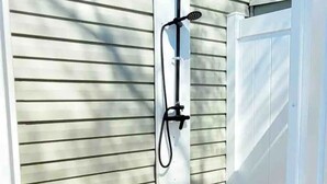 A white metal gate with a hose attached, leading to a white door. - Beechwood by the Bay Dog Friendly (Lower Township)