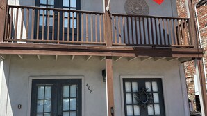 A two-story building with a balcony, a flag, and a number '408' on the wall. - PALM SPRINGS- 2Master Suites, Style & Location! “No chores” at checkout! (Lafayette)