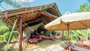 A thatched-roof structure with a hammock, outdoor seating, and a covered patio area. - Longonot Buffaloe's Rest Greenpark Naivasha (Naivasha)