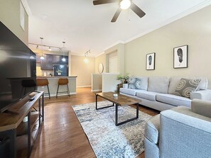 A modern living room with a sofa, coffee table, and dining area.