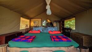 Una habitación con tienda de campaña, una cama, almohadas y un dosel.