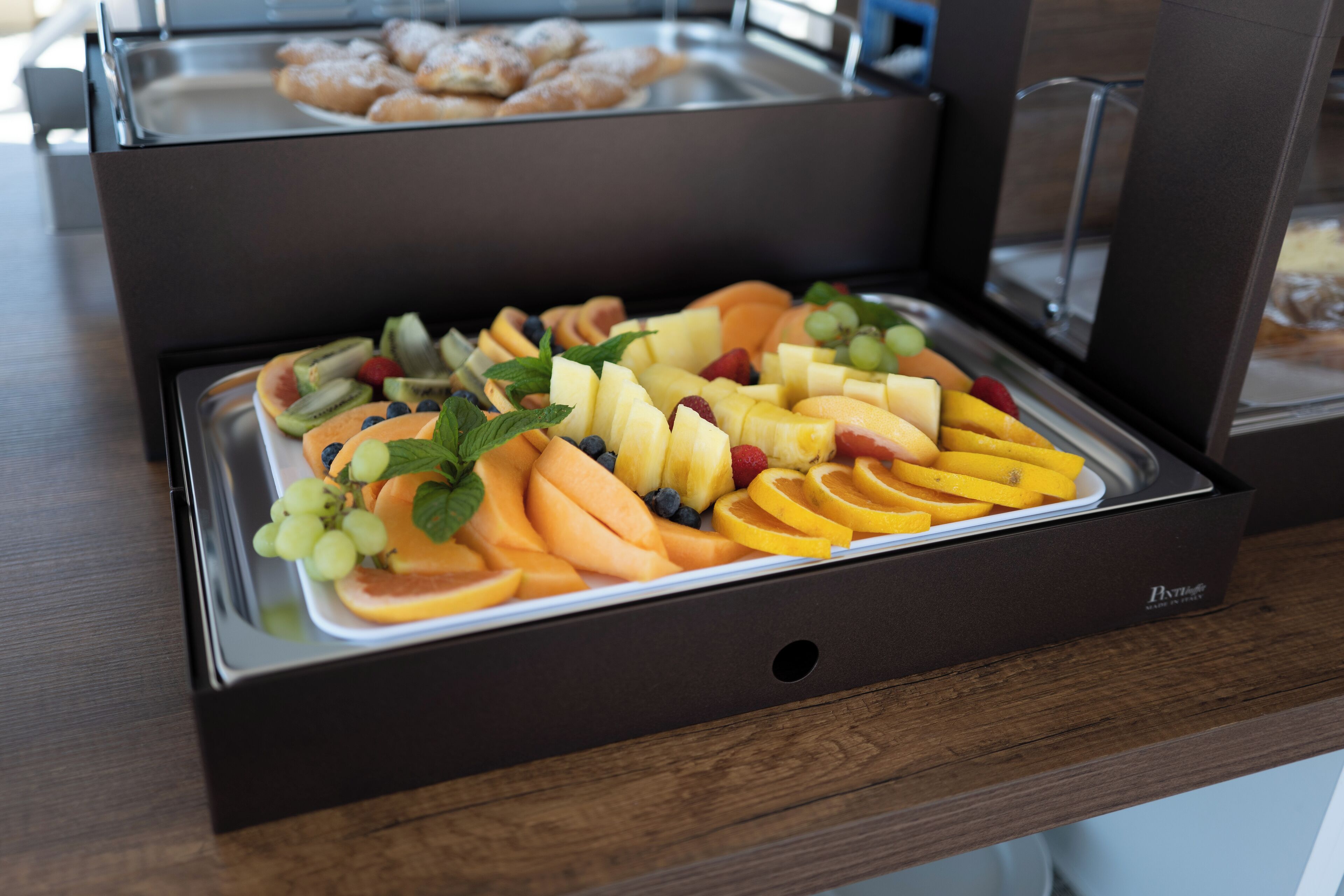 A buffet with a variety of fruits and pastries.