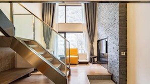 Ein modernes Interieur mit Treppe, einer Couch und einer Steinwand.