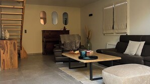 Uma sala de estar moderna com escada, lareira, sofá e mesa de centro.