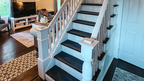 A staircase with white balusters and dark steps leading to a landing. - Large Farmhouse near Pocono attractions! Ping-pong and Pool tables included. (South Sterling)