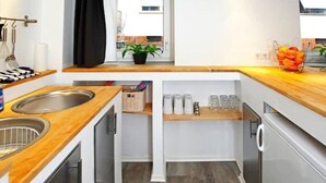 A modern kitchen with wooden countertops, stainless steel sinks, and a built-in oven. - Gemütlich Zentrale Souterraint Wohnung 65qm (Nürnberg)