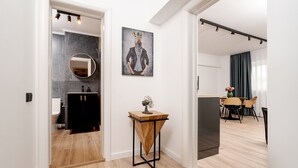 Ein modernes Interieur mit Küche, Essbereich und einem Flur, der zu einem Badezimmer führt.