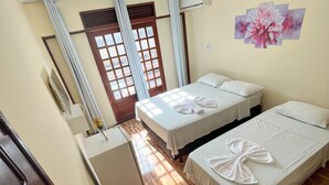Habitación de hotel con dos camas, un escritorio y un aire acondicionado.