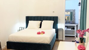 A bedroom with a bed, bedside table, chair, and a view of the outside. - Royal Horses (Overijse)