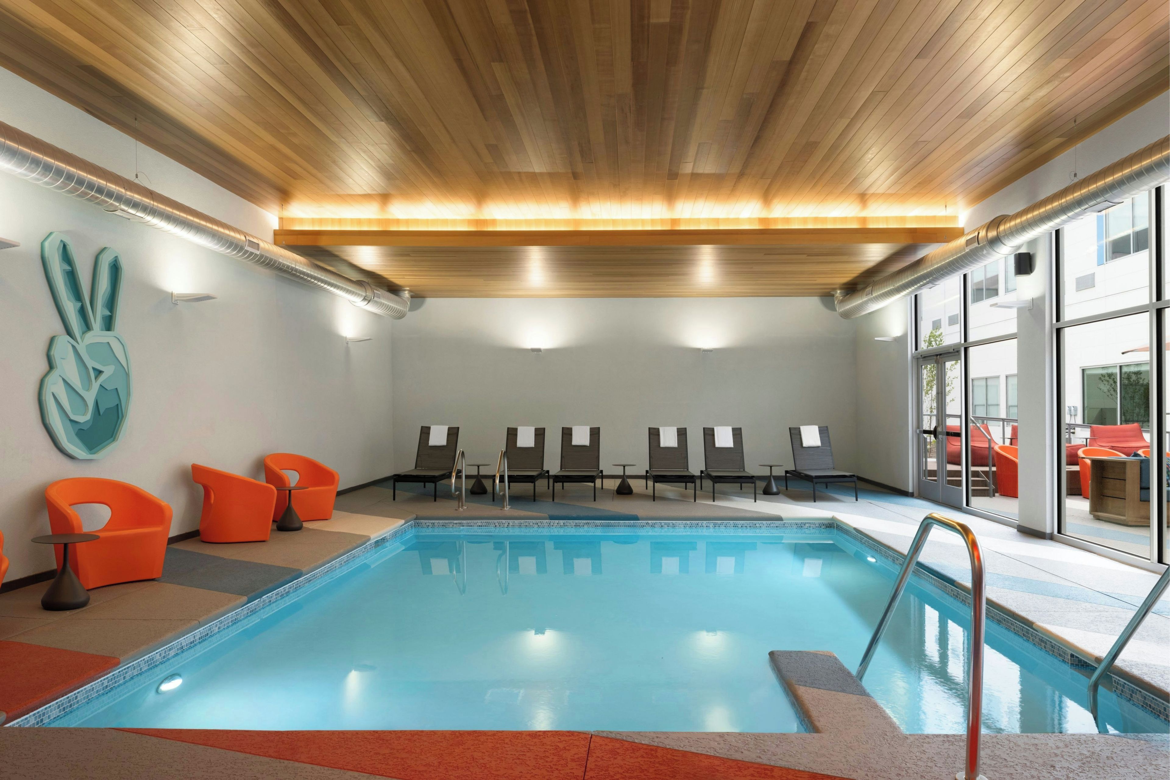 A swimming pool with lounge chairs and a decorative wall.