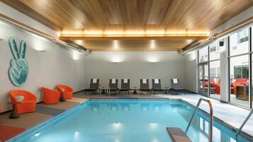 A swimming pool with lounge chairs and a decorative wall.