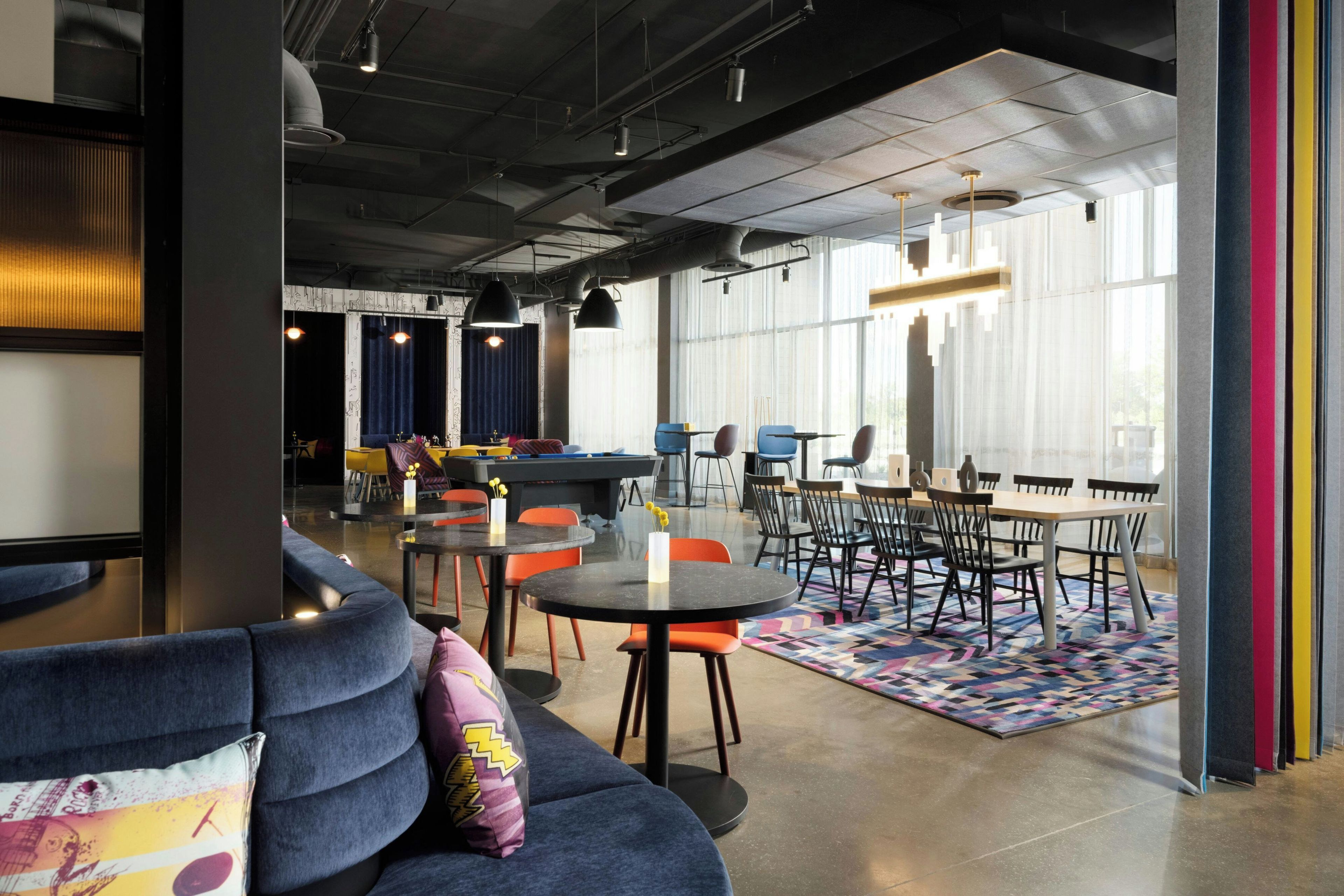 A modern interior with seating areas, tables, and large windows.