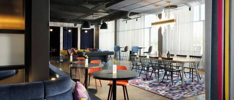 A modern interior with seating areas, tables, and large windows.
