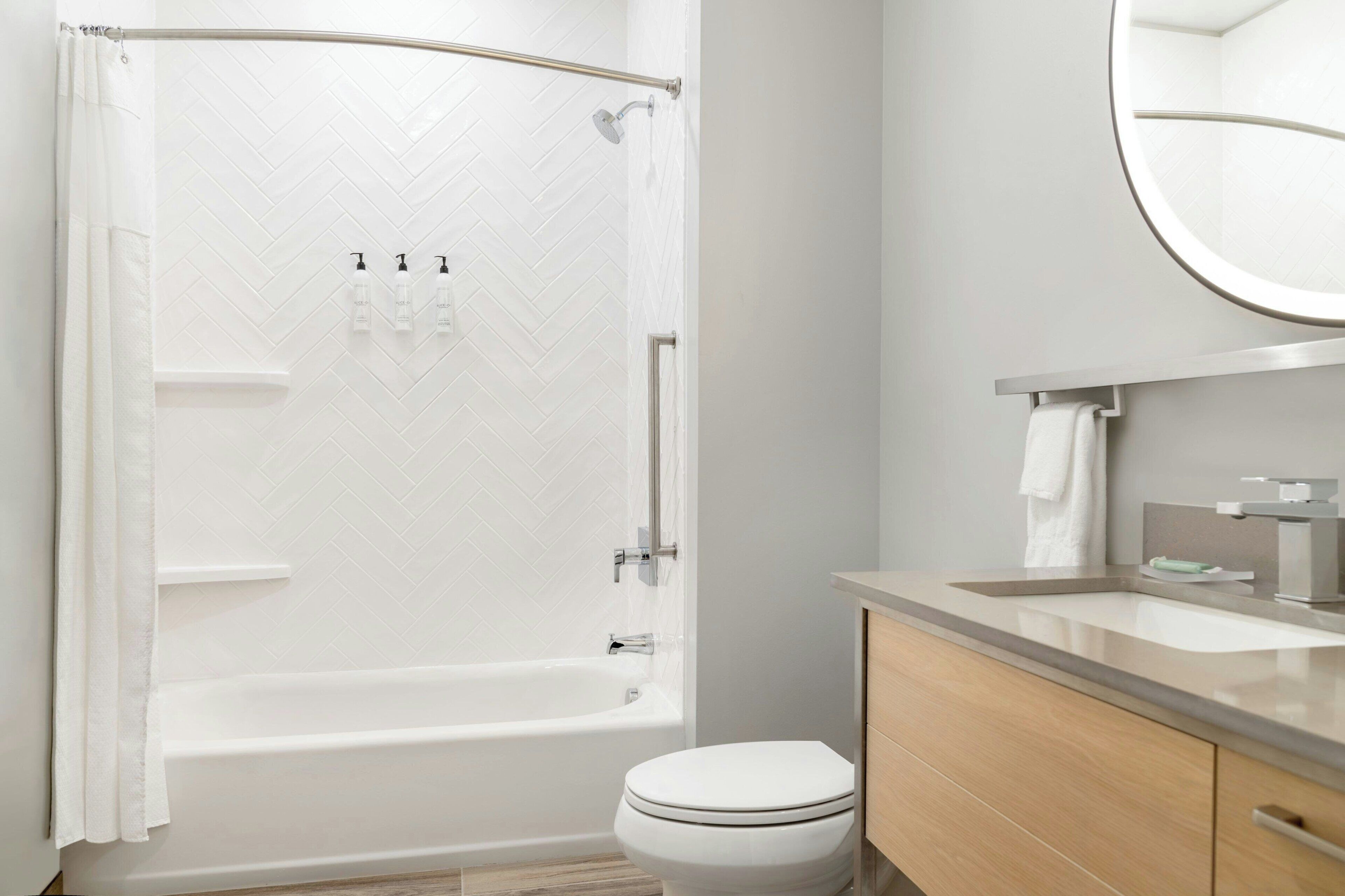 A modern bathroom with a shower, toilet, and vanity.