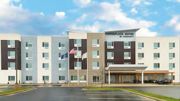 Experience the comfort of Towneplace Suites, featuring a grid-patterned facade and a covered outdoor dining area.