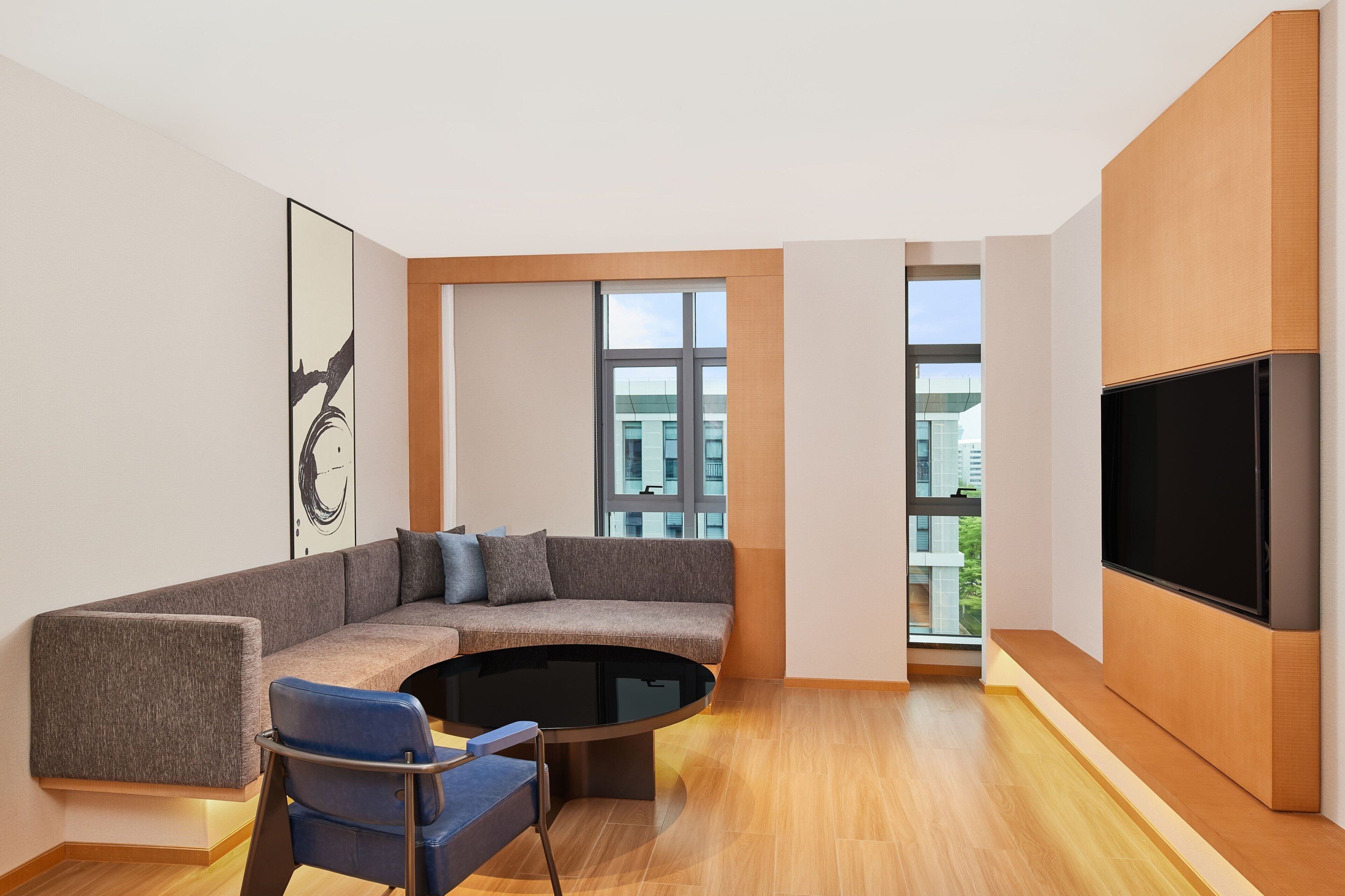 A modern living room with a sectional sofa, a coffee table, and a flat-screen TV.