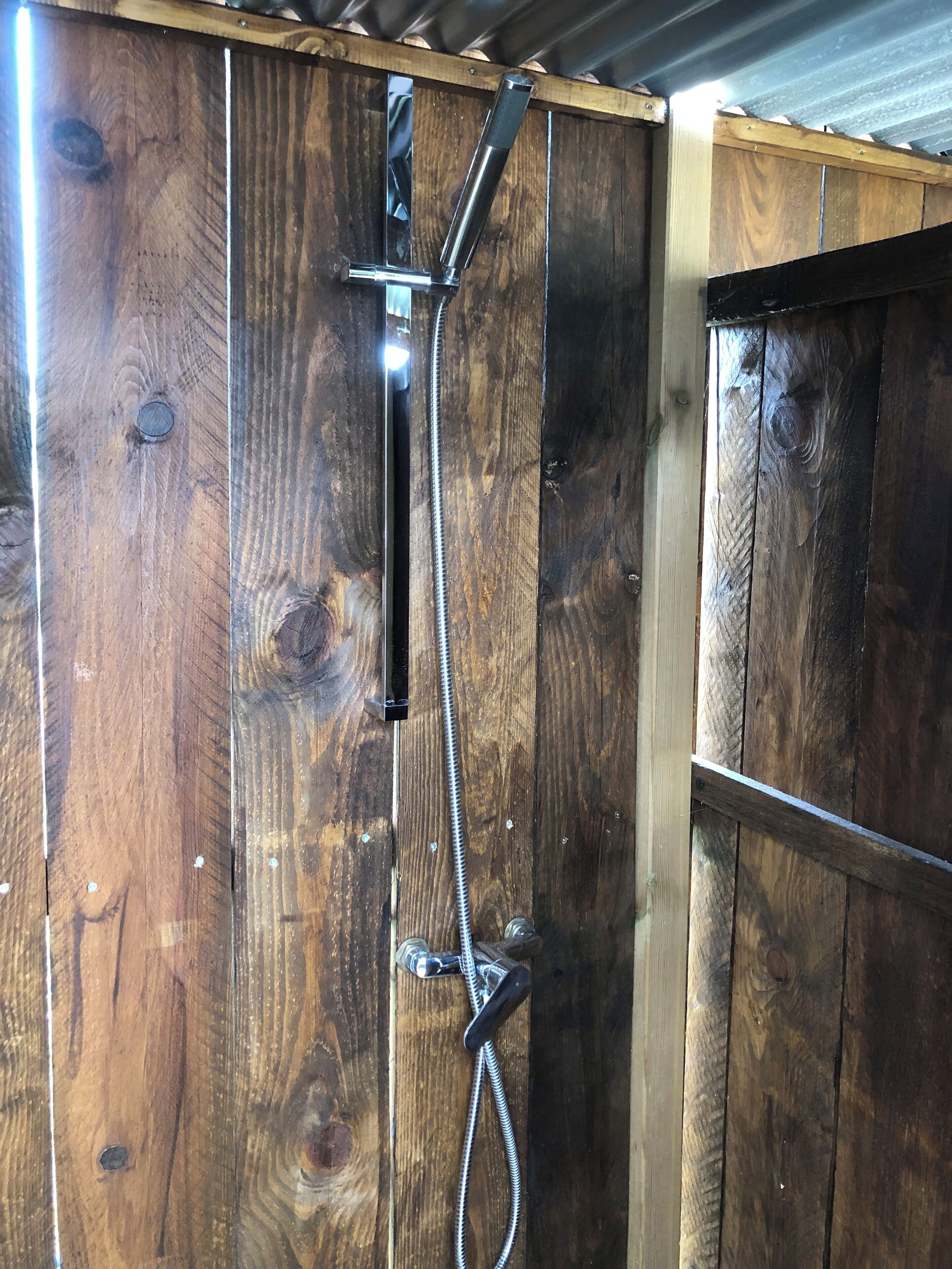 Een douche, handdoeken, zeep, toiletpapier