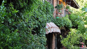 A traditional building with a brick facade, large windows, and a covered porch area.
