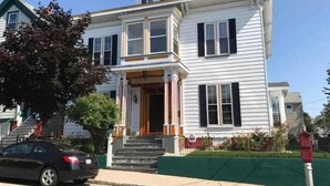 A two-story house with a front porch, a visible staircase, and a mailbox.