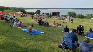 An outdoor event with a stage and audience on a grassy field by a lake. - Island View House BnB Self Check-In # 4 / Free Off-Street Parking  (Portland)