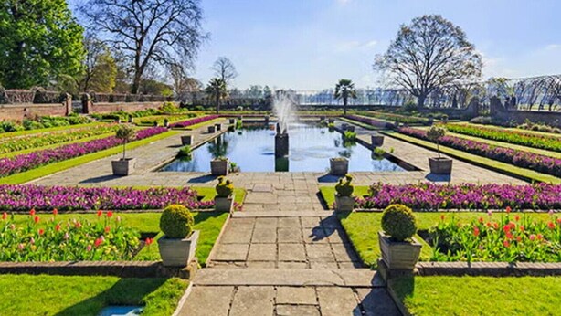 A formal garden with a central fountain, symmetrical flower beds, and a stone pathway leading to the fountain. - BRAND NEW The Palms: Luxury 4-6ppl Apartment (Greater London)