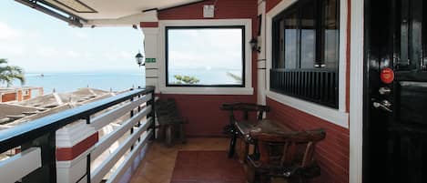 Ein Balkon mit Blick auf das Meer, einem Tisch und zwei Stühlen.