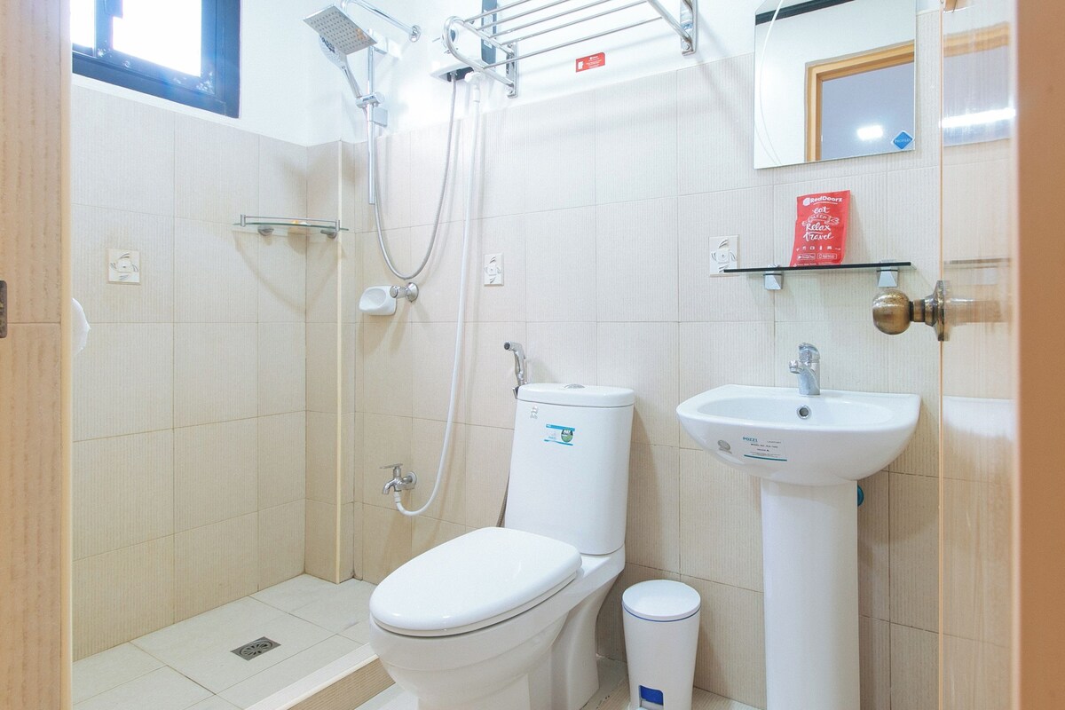 Ein kleines, sauberes Badezimmer mit Toilette, Waschbecken und Dusche.