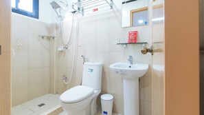 Ein kleines, sauberes Badezimmer mit Toilette, Waschbecken und Dusche.