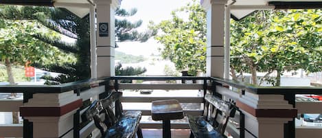 A covered outdoor seating area with benches and a view of the street.