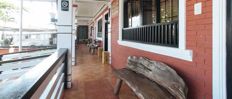 A corridor with a bench, a 'No Smoking' sign, and a view of the street outside.