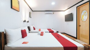 Une chambre d’hôtel avec deux lits, chacun agrémenté de draps blancs et de touches de couleur rouge, un téléviseur à écran plat fixé au mur et une porte en bois avec un panneau de verre décoratif.