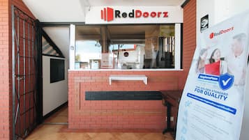 A RedDoorz store with a brick facade, a glass window, and a sign indicating a WiFi zone.