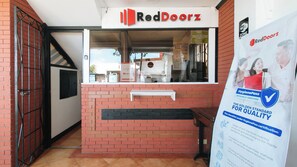 Un établissement RedDoorz avec une façade en briques, une vitrine et un panneau indiquant une zone Wi-Fi.