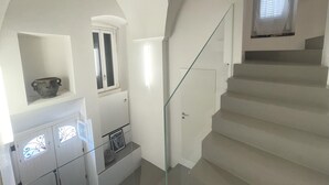 A modern interior with a staircase, a glass railing, and a window with blinds. - Casa Matilda in Fasano (Fasano)