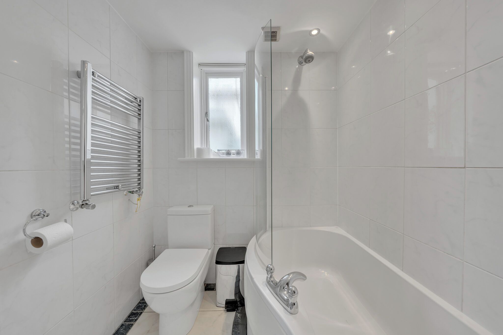 A modern bathroom with a toilet, bidet, and bathtub.