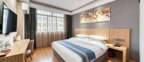 A hotel room with a bed, a desk, a chair, a TV, a painting, and a window.