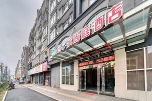 A hotel with a glass facade, multiple floors, and a visible entrance with signage.